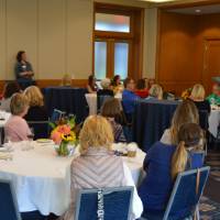 Overview photo of people sitting at the tables listening to a speaker